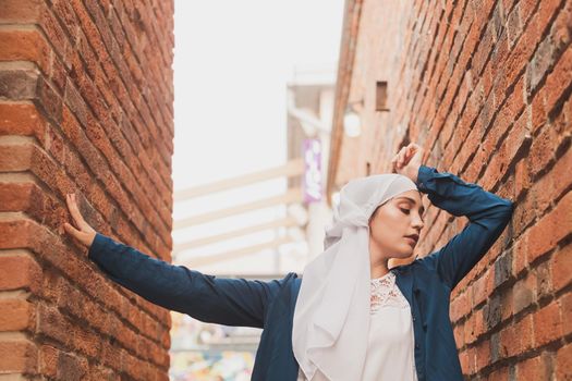 Modern muslim girl fashion with hijab.Beautiful Muslim female model wearing hijab and casual outfit posing on urban background.