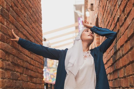 Modern muslim girl fashion with hijab.Beautiful Muslim female model wearing hijab and casual outfit posing on urban background.