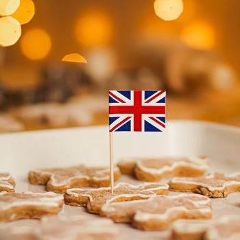 British holiday and Christmas baking concept. Union Jack flag of Great Britain and gingerbread men biscuits in the kitchen in England.