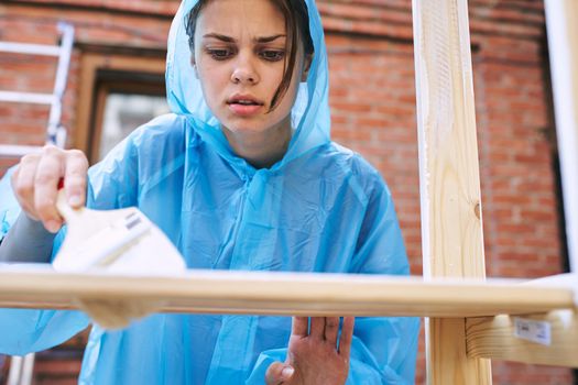 cheerful woman with a paint brush to paint wooden fittings. High quality photo
