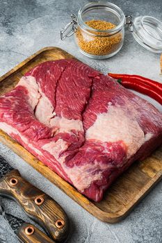 Raw piece of marble beef brisket set,with ingredients for smoking making barbecue, pastrami, cure, on gray stone background