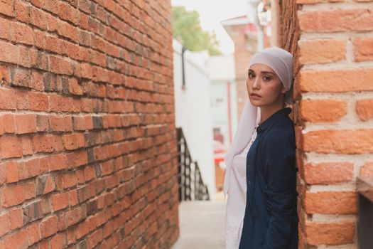 Modern muslim girl fashion with hijab.Beautiful Muslim female model wearing hijab and casual outfit posing on urban background.
