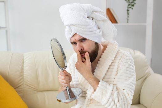 Bearded man checking his skin of face. Spa, body and skin care for male