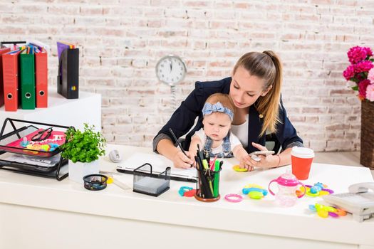 Mom and businesswoman working with laptop computer at home and playing with her baby girl. Horizontal shape, front view, waist up