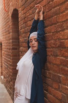 Modern muslim girl fashion with hijab.Beautiful Muslim female model wearing hijab and casual outfit posing on urban background.