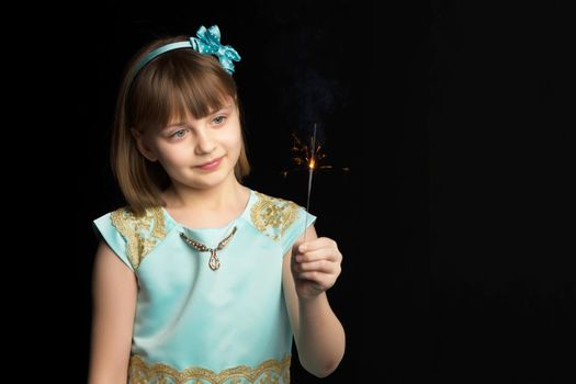 little girl holding firewors on black background