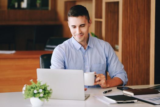 Male marketing managers drink coffee while working to reduce drowsiness before using computers, iPads, and marketing analysis papers