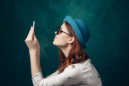 fashionable woman in blue hat with phone in hands communication technology. High quality photo