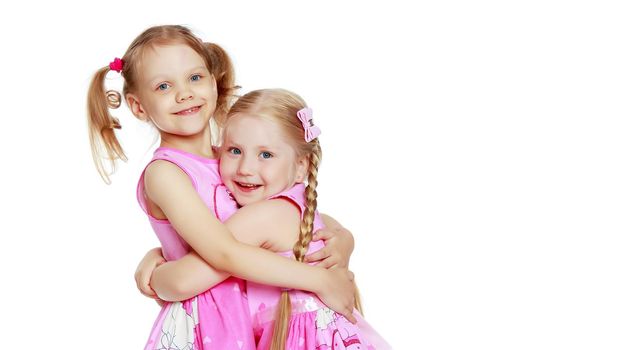 Two cute little girls in full growth, in the studio on a white background. The concept of a happy childhood, Beauty and fashion. Isolated.