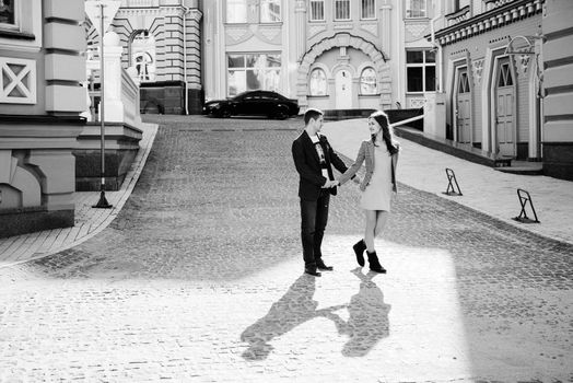 guy and a girl happily walk in the morning on the empty streets of old Europe