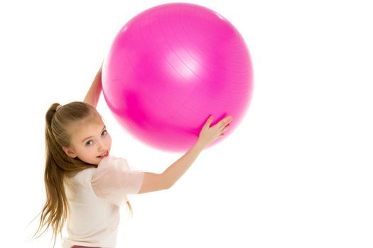 Beautiful little girl is playing with a big ball for fitness. Sports concept, happy childhood. Isolated over white background.