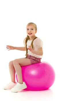 Beautiful little girl is playing with a big ball for fitness. Sports concept, happy childhood. Isolated over white background.