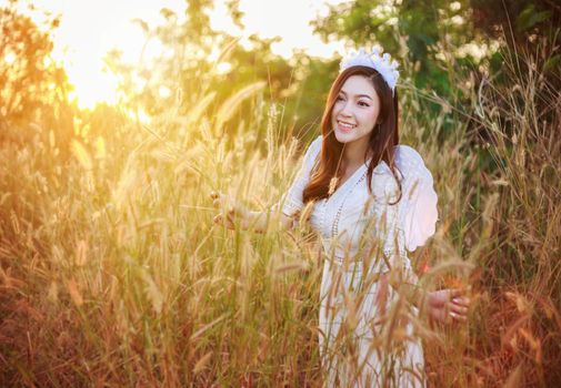 beautiful angel woman in a grass field with sunlight