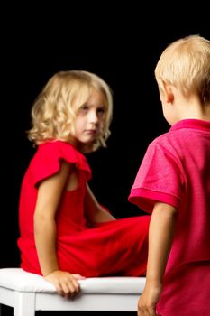 Brother and sister are discussing something. Blurred frame. Isolated over black background.