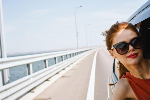 woman looking out of car window wearing sunglasses travel lifestyle. High quality photo