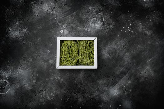 Spinach pasta pack set, on black dark stone table background, top view flat lay, with copy space for text