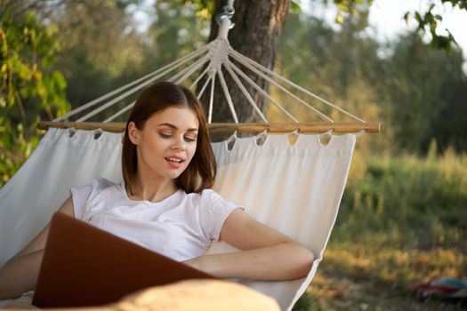 woman with laptop and lies in a hammock vacation nature freelance. High quality photo