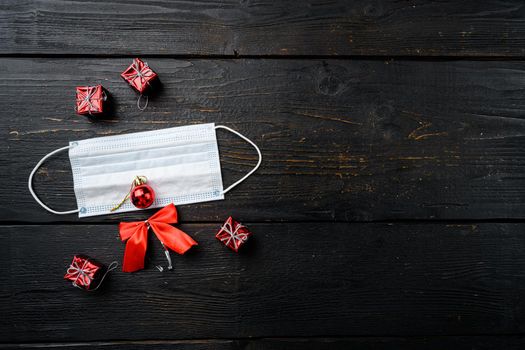 Christmas face from decorations and mask set, on black wooden table background, top view flat lay, with copy space for text