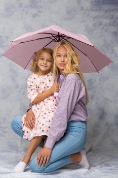 Beautiful young girl hugging her little sister. The concept of a happy childhood, family values.