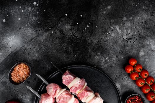 Meat in a barbecue marinade on skewers set, top view flat lay, with copy space for text, on black dark stone table background