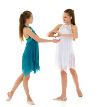 Two adorable girls gymnasts folded hands in the form of a heart. Sign of love. Isolated on a white background.