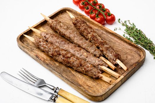 Grilled Lula kebab on skewers with spices set, on white stone table background