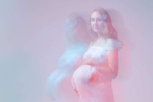 Elegant pregnant young woman standing wearing light fabric. Pregnancy, fantasy and fairy tale.