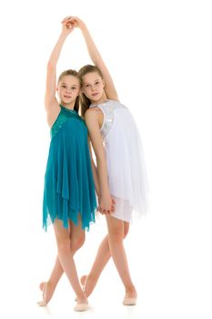 Pretty Gymnasts Performing Rhythmic Gymnastics Exercise, Two Beautiful Teen Sisters Dancing Wearing Sport Dresses, Two Girls Posing in Studio Against White Background