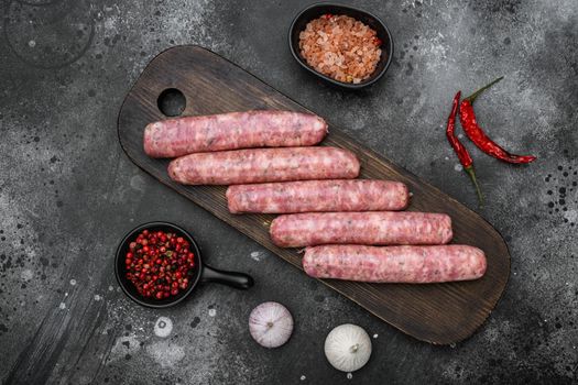 A natural raw sausage set, on black dark stone table background, top view flat lay