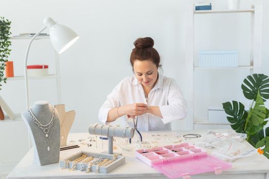 Professional jewelry designer making handmade jewelry in studio workshop. Fashion, creativity and handmade concept.