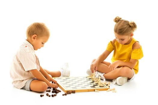 Couple boy and girl playing a board game of chess, thinking about the action and sitting on the floor. isolated on white background.