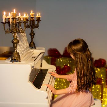 Beautiful Girl Playing Piano and Looking at Burning Candles Standing on Musical Instrument, Side View of Adorable Smiling Girl Wearing Nice Pink Dress, Lovely Child Enjoying with Classical Piano
