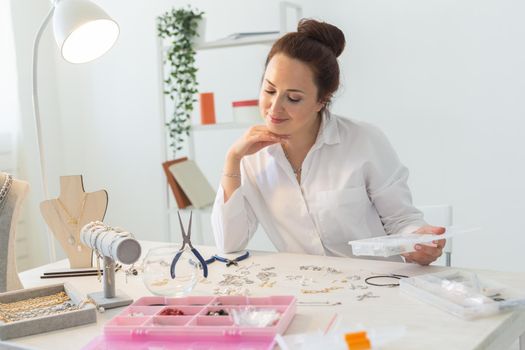 Professional jewelry designer making handmade jewelry in studio workshop. Fashion, creativity and handmade concept.