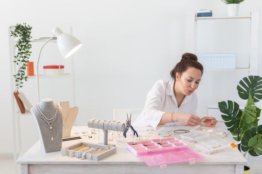 Professional jewelry designer making handmade jewelry in studio workshop. Fashion, creativity and handmade concept.
