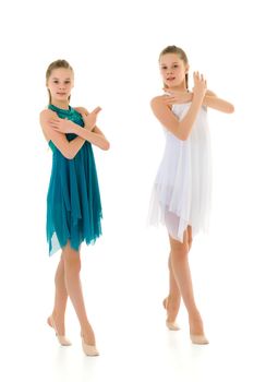 Pretty Gymnasts Performing Rhythmic Gymnastics Exercise, Two Beautiful Teen Sisters Dancing Wearing Sport Dresses, Two Girls Posing in Studio Against White Background