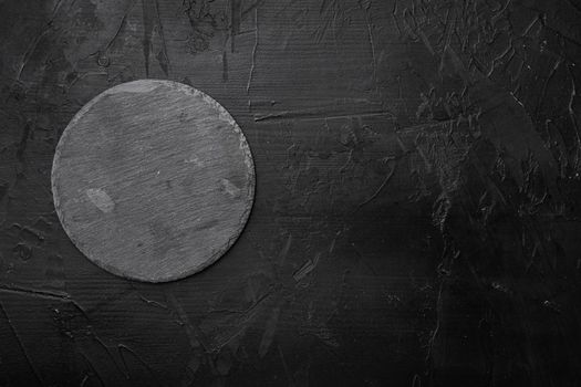 Slate stone cutting board set with copy space for text or food with copy space for text or food, top view flat lay, on black dark stone table background