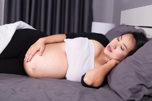 pregnant woman sleeping on bed in the bedroom at home