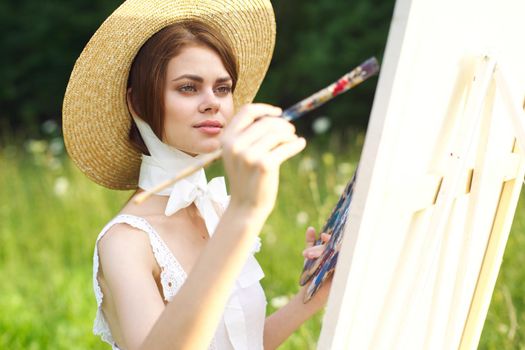 Woman in white dress artist paints on nature palette creative. High quality photo