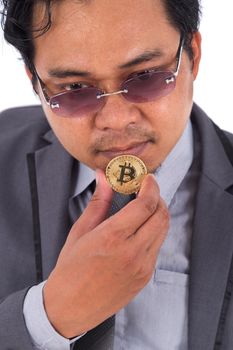 man holding golden bitcoin in hand isolated on a white background