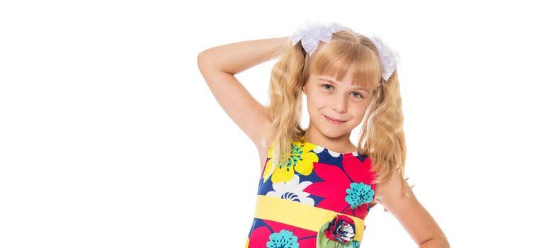 A beautiful little girl straightens her hair on her head. The concept of beauty and fashion, photo on the cover of the magazine.