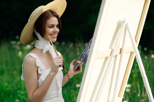 Woman in white dress artist easel painting nature landscape. High quality photo