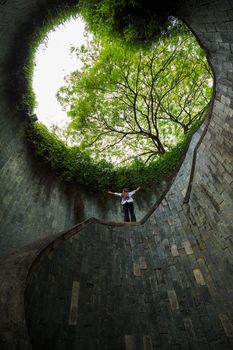 woman hands up at underground crossing in tunnel at Fort Canning Park, Singapore