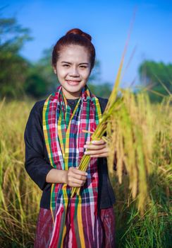 farmer woman holding rice in field, Thailand