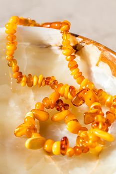 Solar beads of fiery amber on onyx marble background. Natural stone backdrop.