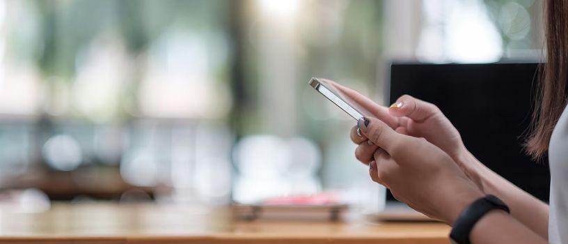 Close up hand of woman using smartphone, texting text message, hipster touch screen on smartphone light bokeh, girls using in hands cellphone close up, online internet