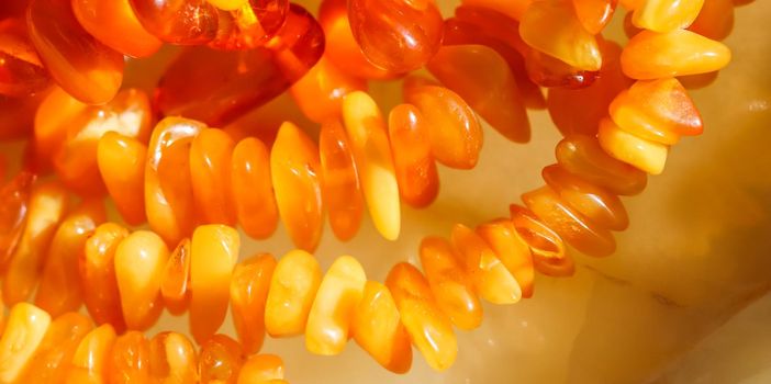 Sunny beads of fire amber. Natural gemstone background, jewelry concept