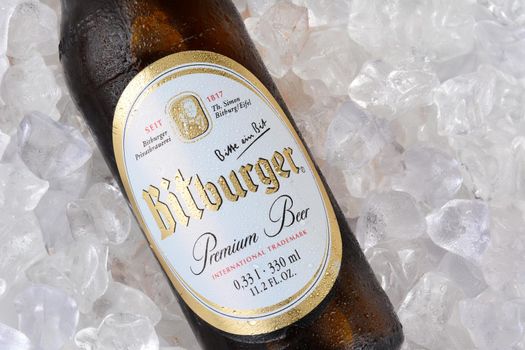 IRVINE, CA - JANUARY 11, 2015: A closeup of a bottle of Bitburger Beer on a bed of ice. Bitburger is a German family business with around  that in 2012 produced around 750 million litres of beer.