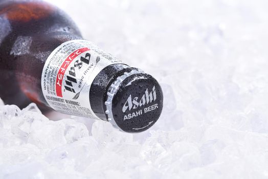 IRVINE, CA - AUGUST 26, 2015: A bottle of Asahi Super Dry Beer closeup on a bed of ice. Asahi was founded in Osaka, Japan in 1889 as the Osaka Beer Company.