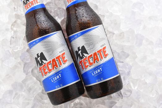IRVINE, CA - JUNE 14, 2017: Tecate Light bottles on Ice.  Two bottles of Tecate Light, a popular pale lager named after the city of Tecate, Baja California, where it was first produced in 1943.