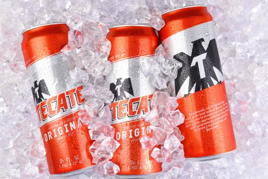 IRVINE, CALIFORNIA - MARCH 29, 2018: Three King Cans of Tecate Original beer in ice. Cuauhtemoc Moctezuma Brewery is a major brewer based in Monterrey, Nuevo Leon, Mexico, founded in 1890.
